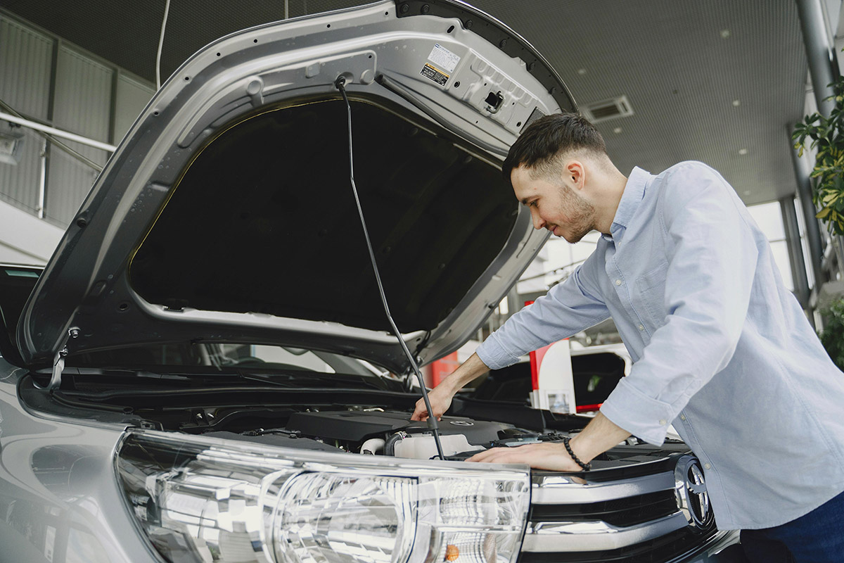 Man Checking the Engine of a Car